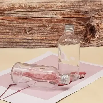 Flacon 100 ml en verre transparent avec bouchon à vis hermétique argenté - Fatipack Group Emballage Maroc